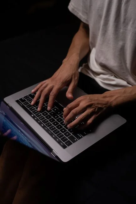 A website wireframe on a macbook screen on an office desk.